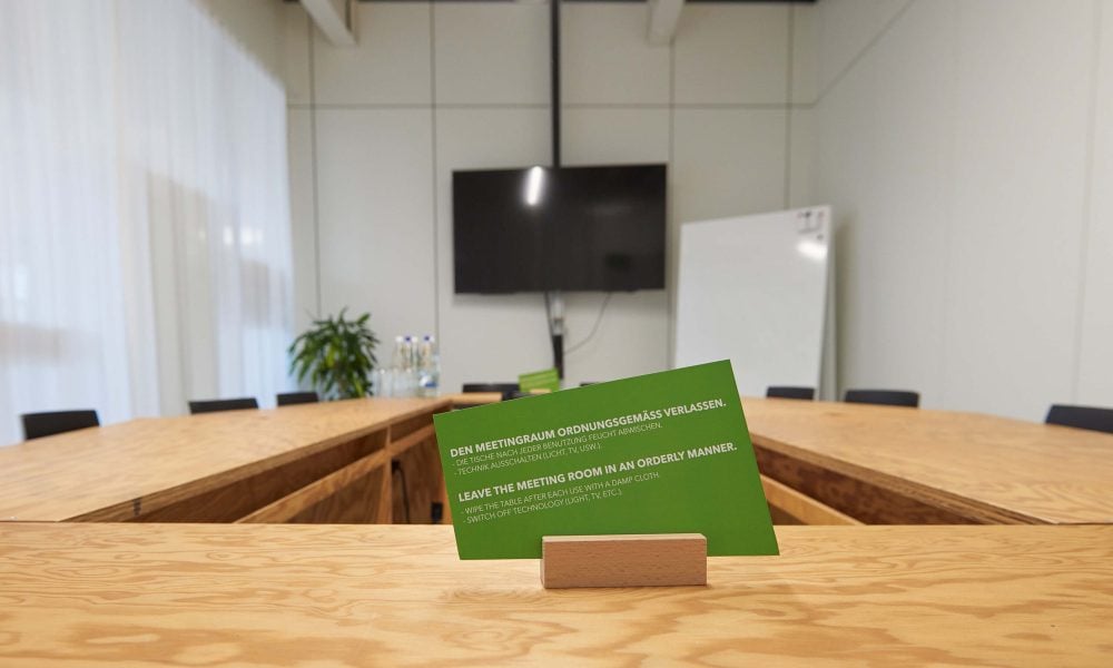Ein kreativer Sitzungsraum mit Whiteboard und Bildschirm.